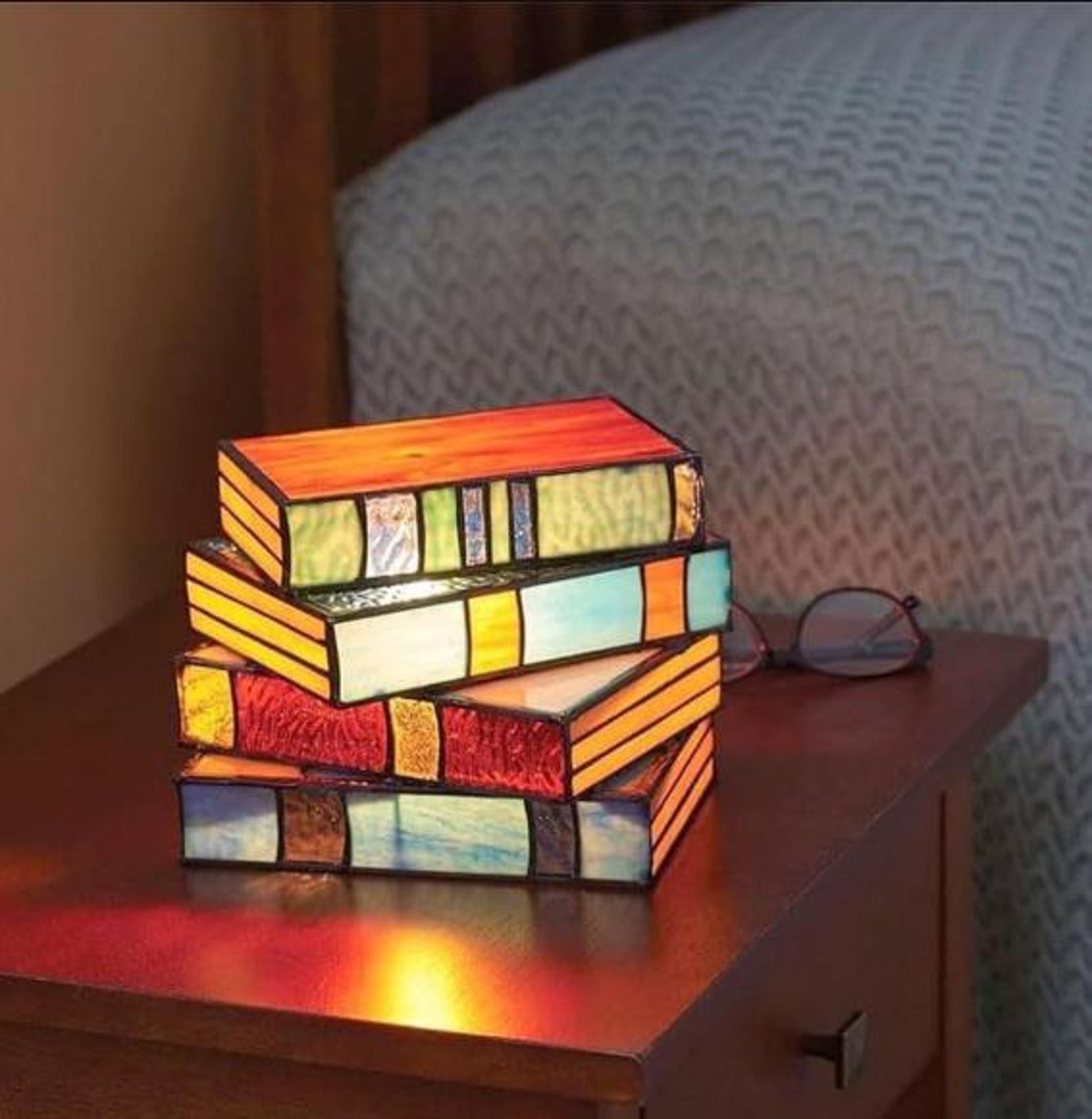 stained glass book lamp set glowing on nightstand for book lovers